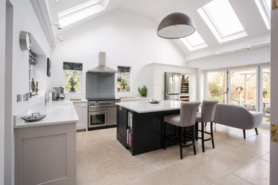 Inspiration for a mid-sized traditional l-shaped separate kitchen in Kent with a farmhouse sink, shaker cabinets, grey cabinets, quartzite benchtops, white splashback, stainless steel appliances, ceramic floors, with island, beige floor and white benchtop.
