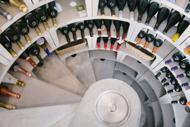 Design ideas for a large wine cellar in Sussex with concrete flooring, display racks and grey floors.