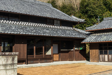 Modelo de fachada de casa marrón y gris de estilo zen extra grande de dos plantas con tejado a dos aguas y tejado de teja de barro