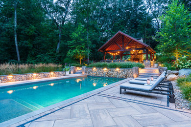 Foto de piscina contemporánea grande rectangular en patio trasero con adoquines de hormigón