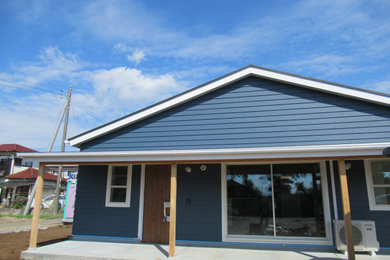 Imagen de fachada de casa azul y negra marinera de tamaño medio de una planta con revestimientos combinados
