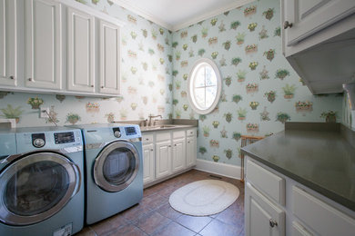 This is an example of a traditional laundry room in Atlanta with an undermount sink, raised-panel cabinets, white cabinets, blue walls and a side-by-side washer and dryer.