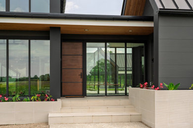 Entryway - contemporary ceramic tile and gray floor entryway idea in Columbus with a medium wood front door