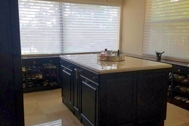 Huge elegant gender-neutral marble floor and beige floor dressing room photo in Miami with raised-panel cabinets and dark wood cabinets