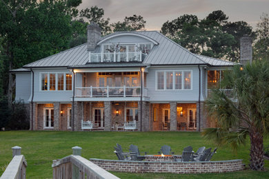 Large coastal multicolored three-story brick and board and batten house exterior idea in Other with a metal roof and a gray roof