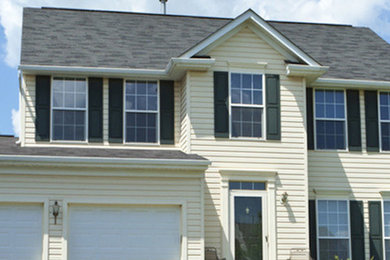 Example of a beige two-story exterior home design in Chicago