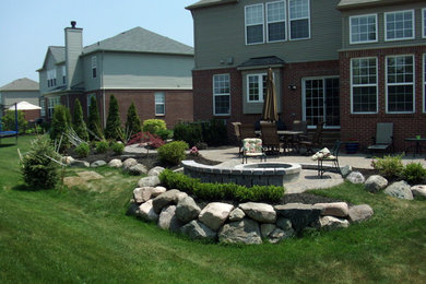 Photo of a contemporary garden in Detroit with a fire feature and brick pavers.