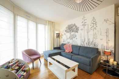 Exemple d'un salon chic de taille moyenne avec un mur beige, un sol en bois brun et du papier peint.