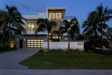 Mid-sized modern multicolored three-story mixed siding exterior home idea in Miami with a mixed material roof