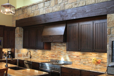 Mountain style galley concrete floor open concept kitchen photo in Austin with a farmhouse sink, beaded inset cabinets, dark wood cabinets, granite countertops, stainless steel appliances and a peninsula