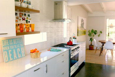 Small minimalist galley eat-in kitchen photo in Los Angeles with a farmhouse sink, flat-panel cabinets, white cabinets, quartz countertops, white backsplash, porcelain backsplash, stainless steel appliances and no island