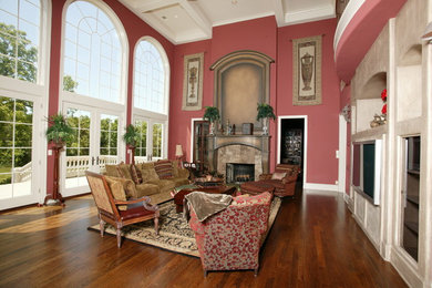 Family room - huge mediterranean open concept medium tone wood floor family room idea in Kansas City with red walls, a standard fireplace and a stone fireplace