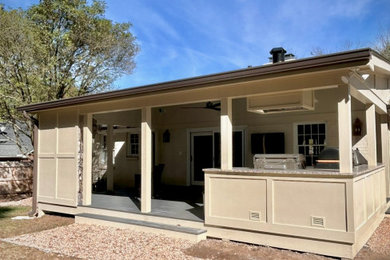 This is an example of a large traditional back porch design in Charlotte with a fireplace and a roof extension.