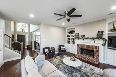 Large transitional dark wood floor living room photo in Dallas with beige walls, a standard fireplace and a brick fireplace