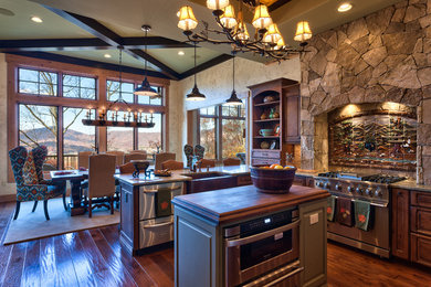 Eat-in kitchen - rustic u-shaped eat-in kitchen idea in Other with a farmhouse sink, raised-panel cabinets, dark wood cabinets, wood countertops, stainless steel appliances, white backsplash and stone tile backsplash
