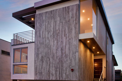 Example of a minimalist three-story stone flat roof design in Los Angeles
