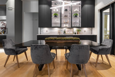 Mid-sized trendy galley light wood floor, brown floor and shiplap ceiling eat-in kitchen photo in Oklahoma City with a single-bowl sink, flat-panel cabinets, black cabinets, quartzite countertops, white backsplash, stone slab backsplash, paneled appliances, an island and white countertops