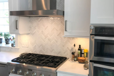 Example of a huge transitional l-shaped medium tone wood floor eat-in kitchen design in Boston with shaker cabinets, white cabinets, quartzite countertops, gray backsplash, stainless steel appliances, an island and white countertops
