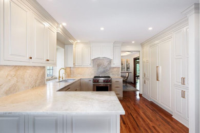 Mid-sized elegant u-shaped medium tone wood floor and brown floor eat-in kitchen photo in Columbus with beaded inset cabinets, white cabinets, quartzite countertops, beige backsplash, granite backsplash, paneled appliances, a peninsula and beige countertops