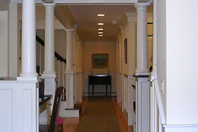 Inspiration for a mid-sized transitional light wood floor hallway remodel in Boston with white walls