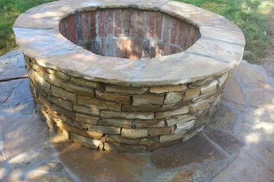 Small elegant backyard stone patio photo in Oklahoma City with a fire pit and no cover