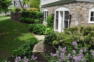 Design ideas for a large traditional shade side yard stone landscaping in Boston for spring.