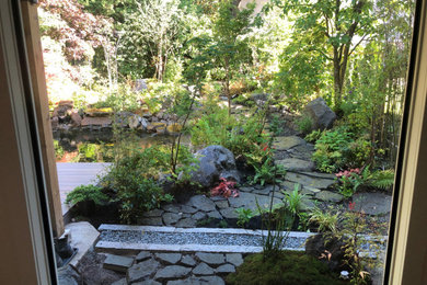 Photo of a mid-sized modern partial sun backyard stone formal garden.