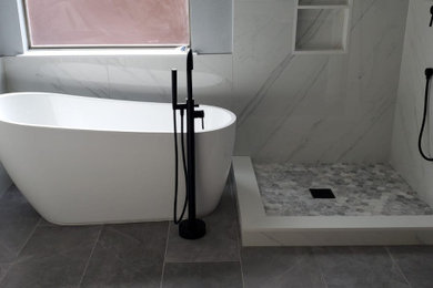 Example of a mid-sized minimalist master white tile and marble tile ceramic tile, gray floor and double-sink bathroom design in Dallas with shaker cabinets, black cabinets, a two-piece toilet, blue walls, an undermount sink, a hinged shower door, white countertops, a niche and a built-in vanity