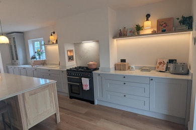 This is an example of a large kitchen in Dorset with an island.