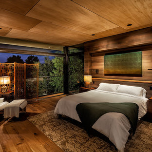 Foto di una camera matrimoniale etnica con pareti marroni, parquet scuro e pavimento marrone