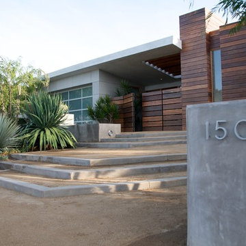 Terraced, broad steps of concrete and decomposed granite lead to front door.