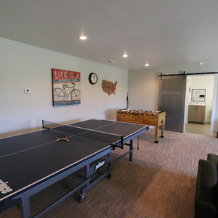 Aménagement d'une salle de séjour industrielle de taille moyenne avec salle de jeu, un mur beige, moquette, une cheminée d'angle, un manteau de cheminée en béton et un téléviseur fixé au mur.