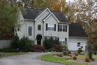Example of a large gray two-story stucco exterior home design in Other