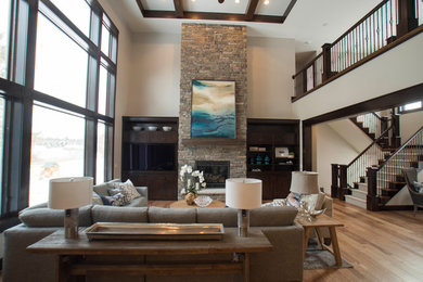 Inspiration for a large craftsman loft-style medium tone wood floor and brown floor family room remodel in Other with a standard fireplace, a stone fireplace and a corner tv