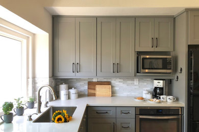 Example of a mid-sized transitional u-shaped porcelain tile and beige floor kitchen design in San Diego with an undermount sink, shaker cabinets, gray cabinets, quartz countertops, white backsplash, glass tile backsplash, black appliances and white countertops