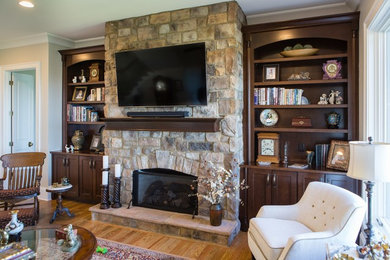 Inspiration for a timeless open concept medium tone wood floor living room remodel in Other with beige walls, a standard fireplace and a stone fireplace