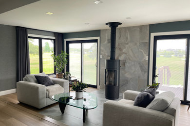 Living room - contemporary vinyl floor, beige floor and wallpaper living room idea in Ottawa with a wood stove and a tile fireplace