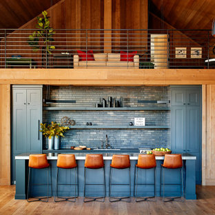 サンフランシスコのビーチスタイルのおしゃれな着席型バー (青いキッチンパネル、サブウェイタイルのキッチンパネル、無垢フローリング、青いキッチンカウンター、アンダーカウンターシンク、シェーカースタイル扉のキャビネット、青いキャビネット) の写真