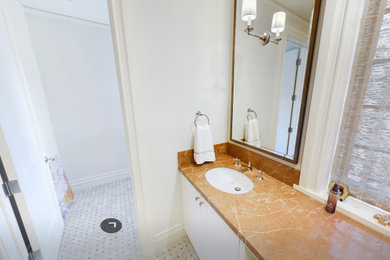 Bathroom - beige tile limestone floor, multicolored floor and double-sink bathroom idea in Denver with raised-panel cabinets, white cabinets, quartzite countertops, a hinged shower door, green countertops, a niche and a built-in vanity