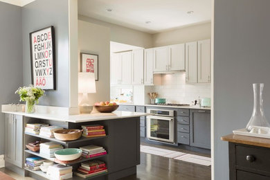 Eat-in kitchen - mid-sized transitional l-shaped dark wood floor and brown floor eat-in kitchen idea in Chicago with an undermount sink, shaker cabinets, white cabinets, quartz countertops, white backsplash, subway tile backsplash, stainless steel appliances, a peninsula and gray countertops