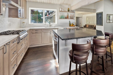 Open concept kitchen - mid-sized cottage l-shaped dark wood floor and brown floor open concept kitchen idea in Other with an undermount sink, shaker cabinets, light wood cabinets, quartz countertops, white backsplash, ceramic backsplash, stainless steel appliances and an island