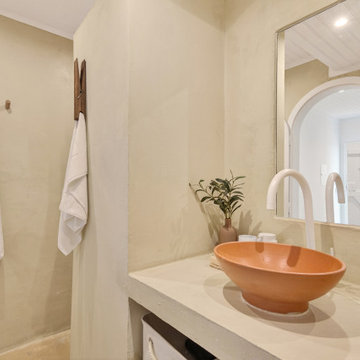 Bathroom with Terracotta Basin and Arched Mirror View