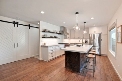 Eat-in kitchen - small contemporary laminate floor and brown floor eat-in kitchen idea in San Francisco with recessed-panel cabinets, white cabinets, white backsplash, ceramic backsplash, stainless steel appliances, an island and gray countertops