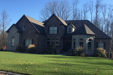 Large two-story brick exterior home photo in Other