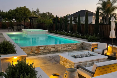 Example of a large trendy backyard stamped concrete and rectangular infinity pool landscaping design in San Francisco