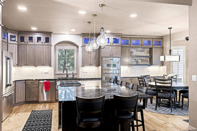 Inspiration for a huge 1960s l-shaped light wood floor eat-in kitchen remodel in Denver with granite countertops, subway tile backsplash, stainless steel appliances, an island and black countertops