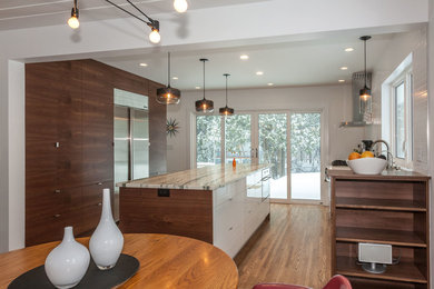 Design ideas for a large contemporary u-shaped eat-in kitchen in Minneapolis with an undermount sink, flat-panel cabinets, dark wood cabinets, marble benchtops, white splashback, subway tile splashback, stainless steel appliances, light hardwood floors and with island.