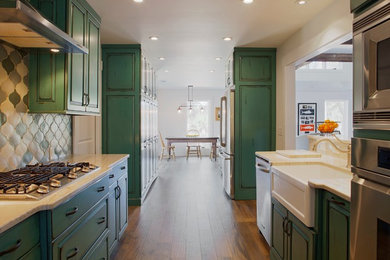 Inspiration for a large coastal galley medium tone wood floor eat-in kitchen remodel in Atlanta with raised-panel cabinets, green cabinets, no island, quartzite countertops, multicolored backsplash, a farmhouse sink, ceramic backsplash and white appliances