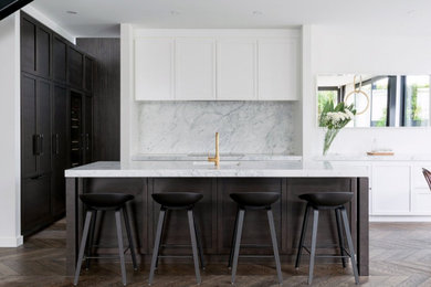 Photo of a large contemporary kitchen in Sydney with shaker cabinets, white cabinets, marble benchtops, white appliances, dark hardwood floors, with island and brown floor.