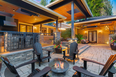 Inspiration for a mid-sized craftsman backyard ground level metal railing outdoor kitchen deck remodel in Seattle with a roof extension